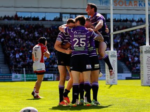 Joe Burgess of Wigan celebrates with team-mates after scoring a try during the Super League match between St Helens and Wigan Warriors at Langtree Park on April 18, 2014