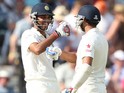 India's Mohammed Shami and India's Bhuvneshwar Kumar celebrate after scoring a half century during the second days play in the first cricket Test match between England and India at Trent Bridge in Nottingham, central England on July 10, 2014