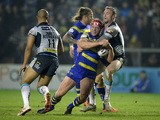 Chris Hill of Warrington Wolves is tackled by Jamie Peacock of Leeds Rhinos during the First Utility Super League match between Warrington Wolves and Leeds Rhinos at The Halliwell Jones Stadium on March 13, 2015