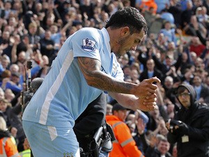 Manchester City's Argentinian striker Carlos Tevez celebrates scoring his third goal with a golf swing celebration during the English Premier League football match between Norwich City and Manchester City at Carrow Road stadium in Norwich, England on Apri