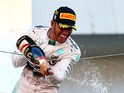 Lewis Hamilton of Great Britain and Mercedes GP celebrates with the trophy on the podium after winning the Formula One Grand Prix of Japan at Suzuka Circuit on September 27, 2015