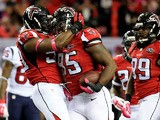 Jonathan Babineaux #95 celebrates with O'Brien Schofield #50 of the Atlanta Falcons after an interception in the first half against the Houston Texans at the Georgia Dome on October 4, 2015