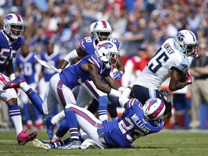  Justin Hunter #15 of the Tennessee Titans gets tackled after a reception by Aaron Williams #23 and Nickell Robey #37 of the Buffalo Bills in the first half at Nissan Stadium on October 11, 2015 in Nashville, Tennessee. 