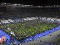 Frightened spectators wait on the pitch at the Stade de France on November 13, 2015