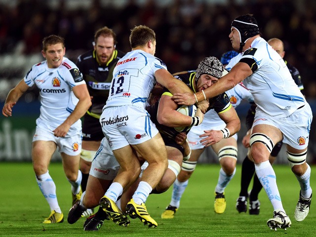 Ospreys player Dan Lydiate runs into Chiefs players Sam Hill (l) and Mitch Lees during the European Rugby Champions Cup Pool 2, round 1 match between Ospreys and Exeter Chiefs at Liberty Stadium on November 15, 2015